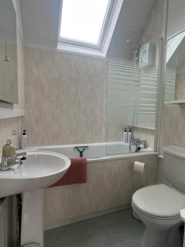 a bathroom with a sink and a toilet and a tub at Dun-Niall Apartment in Oban
