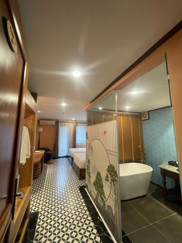 a bathroom with a bath tub and a bedroom at SAPA DEBOUTIQUE Hotel in Sapa