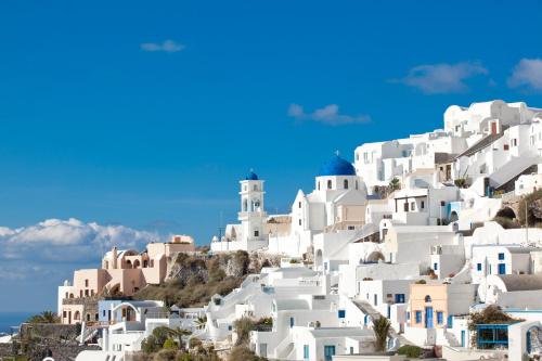 a group of white buildings on a hill at Avianto Suites in Imerovigli
