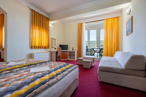 a hotel room with a bed and a couch at Hotel Adria in Neum