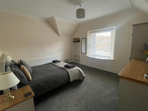 a bedroom with a bed and a window at Dun-Niall Apartment in Oban