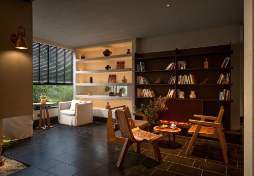 a living room with bookshelves and a table and chairs at Chengdu Yunduo Bieyuan 云朵 Hotel in Chengdu