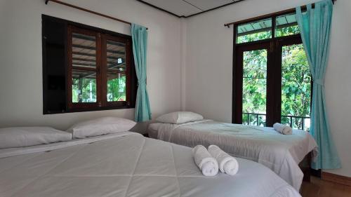 a room with three beds and a window at Sanfhan Resort-SHA Plus in Khao Chai Son