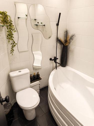 a bathroom with a toilet and a bath tub at Romance Apartments in Panevėžys