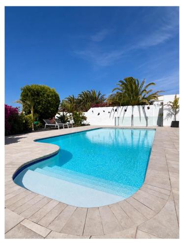 a swimming pool with blue water in a yard at Villa Infinity Exclusive in Tías
