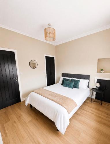 a bedroom with a large white bed with blue pillows at Gladstone Getaway in Peterhead