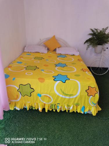 a bed with a yellow blanket with animals on it at Bloo Ivy-Peradeniya in Peradeniya
