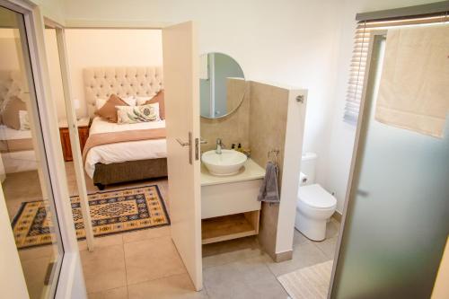 a bathroom with a sink and a bed with a mirror at Jac-Marie guests accommodation in Tzaneen