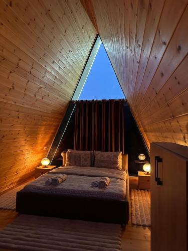 a bed in a room with a large window at The Overlook in Bogë