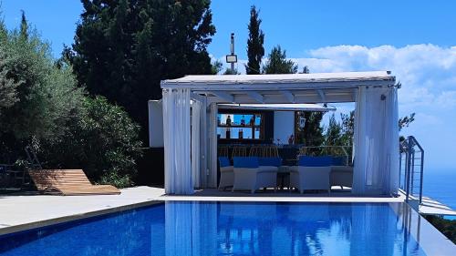 a swimming pool with a gazebo next to a swimming pool at Okeanos Vine Luxury Villa in Athani