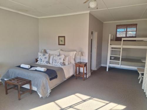 a bedroom with a large bed and a ladder at Blanco Guest Farm - Holiday Resort in Tarkastad