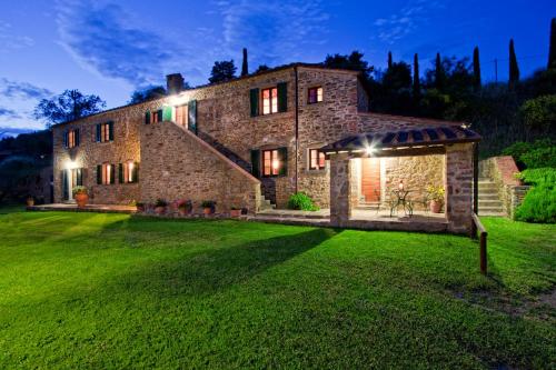 a large stone house with a yard at night at Mulino a Vento in Cortona