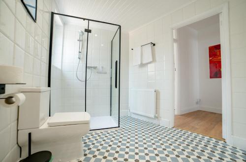 a bathroom with a toilet and a glass shower at High Street Retreat in Whitstable