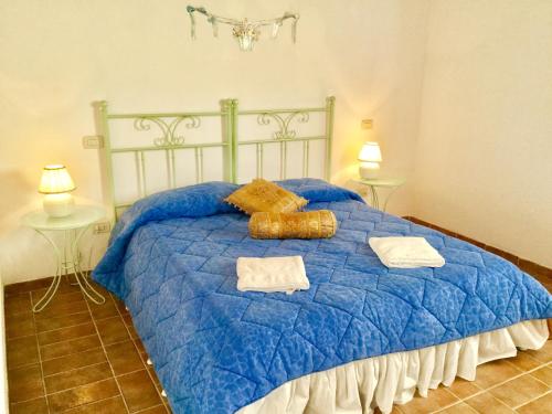 Una cama azul con dos toallas encima. en Podere Fornaci, en Asciano