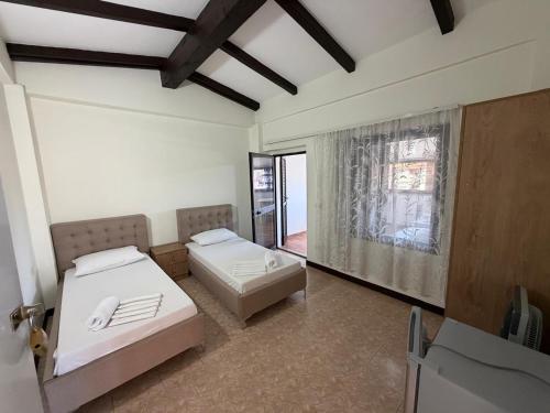 a bedroom with two beds in a room with a window at Villa Emma Durrës in Durrës