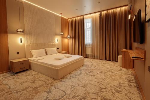 a hotel room with a bed and a television at EUROPA Hotel in Semey