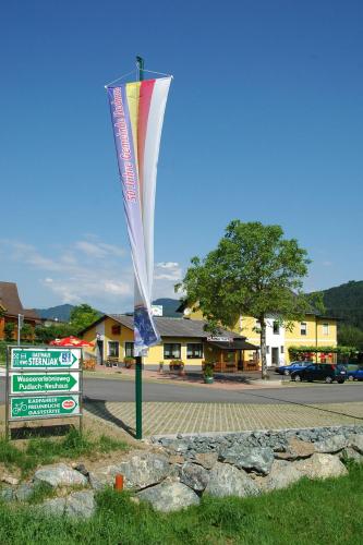 a flag on a pole next to a street at Gasthaus Sternjak in Wunderstätten