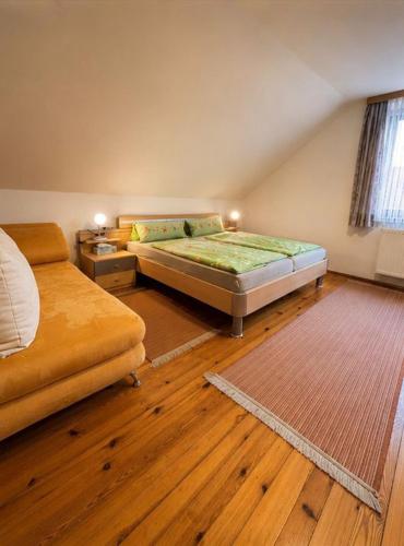 a bedroom with two beds and a wooden floor at Gasthaus Sternjak in Wunderstätten
