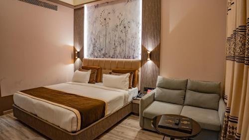a hotel room with a bed and a couch at Hotel Sea N Rock in Thane