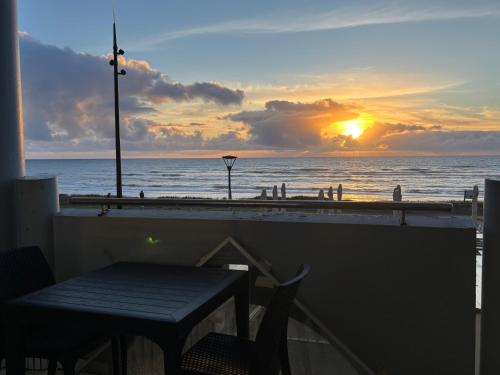 a table and chairs on a balcony with a view of the beach at Le Grand Large - T2 vue océan in Mimizan-Plage