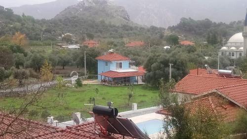 a house with a swimming pool in a village with mountains at Mavi Ev in Köyceğiz