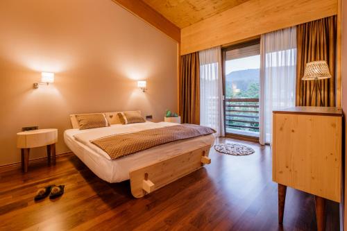 ein Schlafzimmer mit einem Bett und einem großen Fenster in der Unterkunft Bohinj Eco Hotel in Bohinj