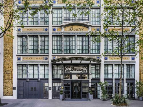 a facade of a building with a store at Boutet Bastille Hotel Paris - MGallery Collection in Paris
