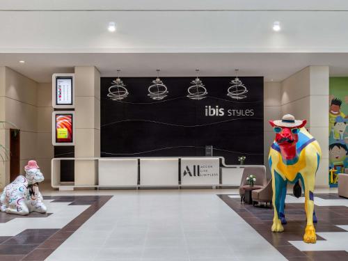 a lobby with a colorful statue of a dog with a hat at Ibis Styles Dragon Mart Dubai in Dubai