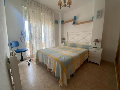 a bedroom with a bed and a chair and a window at Parquemar III-IV Solo Familias!!! Serviplaya in Playa de Xeraco