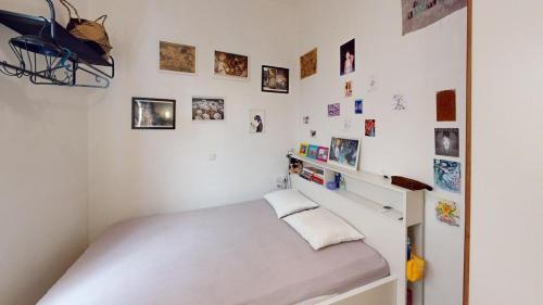 a small bedroom with a bed and pictures on the wall at Amimoni Apartment in Nafplio
