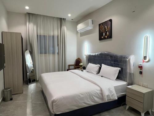 a bedroom with a large white bed in a room at فندق كتيفا نورث in Arar