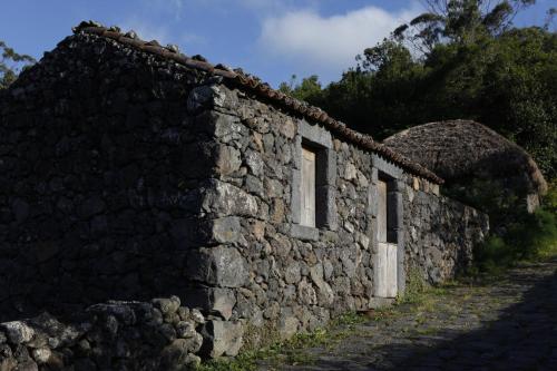 een oud stenen gebouw met een stenen muur bij Quinta Do Martelo in Angra do Heroísmo