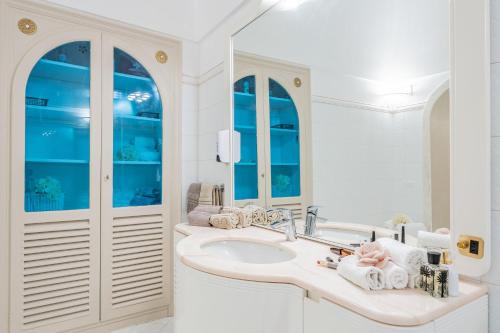 a white bathroom with a sink and a mirror at Domus Almaré in Minori
