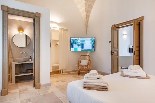 a bedroom with a bed and a sink and a mirror at Masseria Gorgognolo in Ostuni