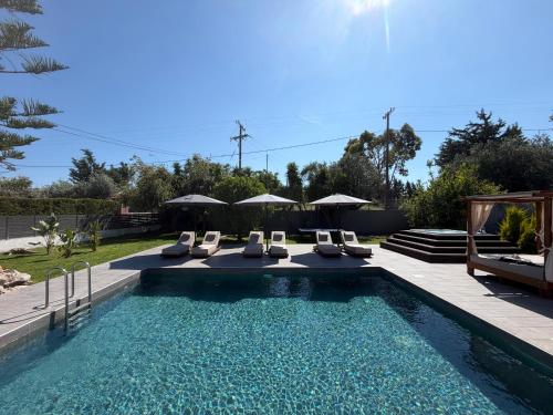 a swimming pool with lounge chairs and a swimming pool at S&T VILLA in Haraki
