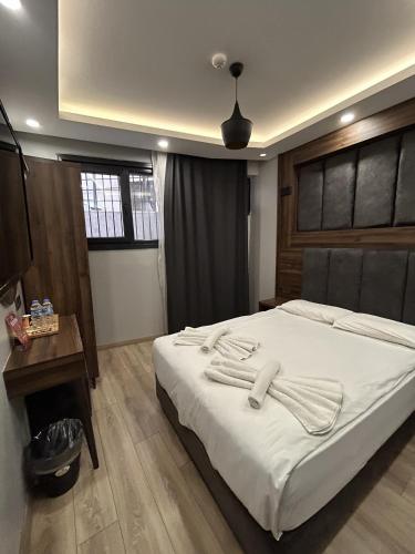 a bedroom with a large bed with white sheets at Basilis Hotel in Istanbul