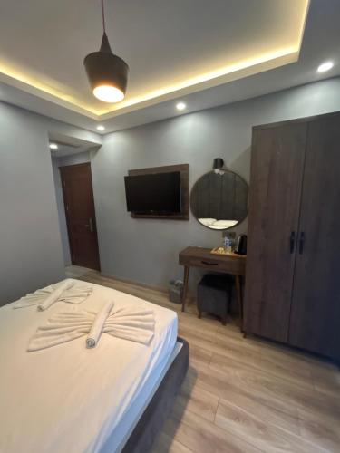 a bedroom with a bed with a television and a desk at Basilis Hotel in Istanbul