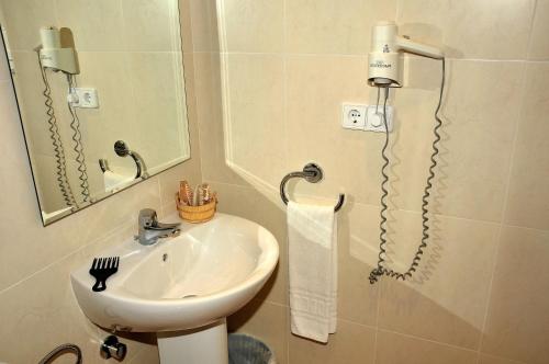 a bathroom with a sink and a mirror at S'Arenal Apartments in Portinatx