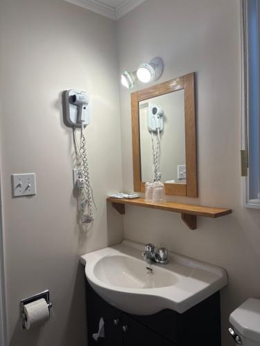 a bathroom with a sink and a mirror at Le Délice Motel Restaurant in Mont-saint-pierre