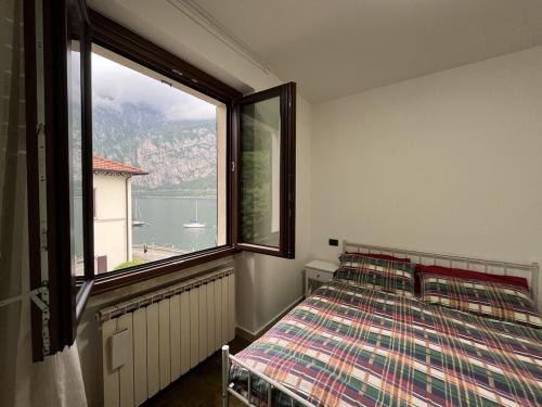 a bedroom with a bed and a large window at Casa delle vele in Valmadrera
