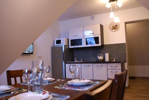 una cucina con tavolo, sedie e frigorifero di Apartament Słoneczny Koscielisko a Kościelisko