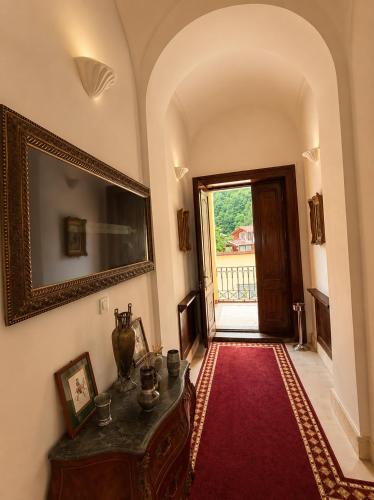 a living room with a table and a red rug at Vila Băncii 1888 by SunGarden in Băile Herculane