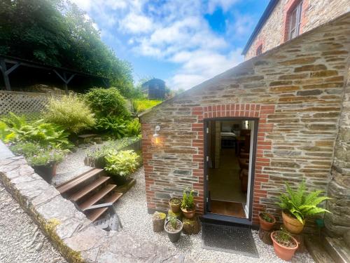a brick building with potted plants in front of it at The Leat at The Old Mill in Tavistock