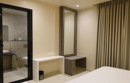 a bathroom with a large mirror and a toilet at Novosol Lux- A Premium Hotel Near Airport in Jaipur
