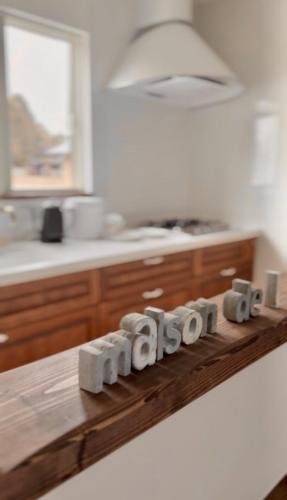 a kitchen counter with a wooden block spelling out the wordarma at Maison de L in Hokuto