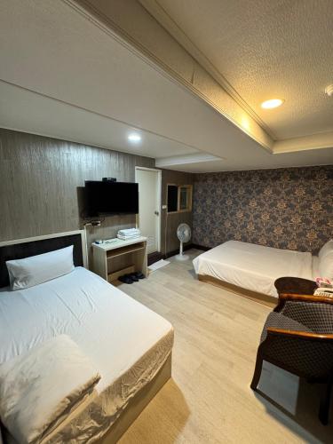 a hotel room with two beds and a television at 貴族旅社 宜蘭縣旅館095號 in Luodong