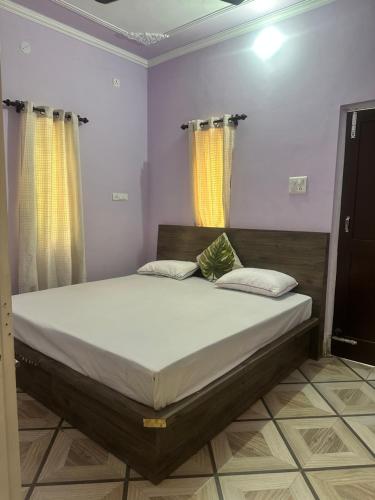 a large bed in a room with yellow curtains at Beyond the city peaks in Kangra Airport