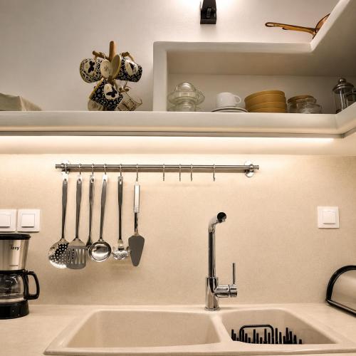a kitchen sink with utensils hanging on a wall at Mare Bay in Adamantas
