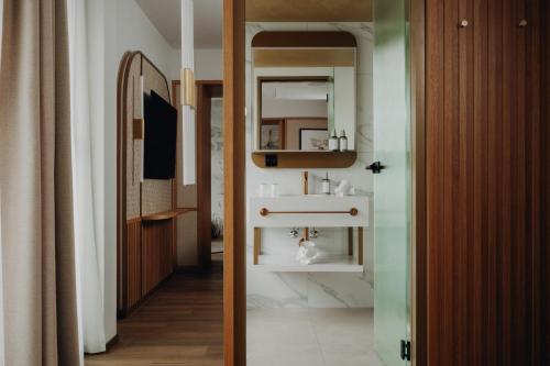 ein Badezimmer mit Waschbecken und Spiegel in der Unterkunft AMERON Luzern Hotel Flora in Luzern