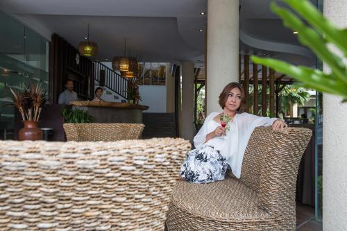a woman sitting in a chair with a drink at Suris Boutique Hotel in Kuta